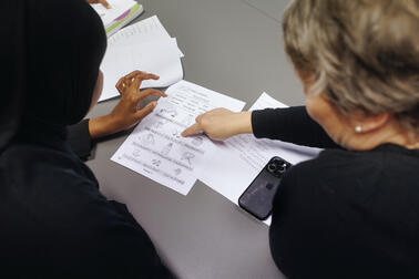 Two people looking at papers.