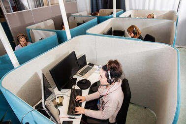 Henkilöitä työskentelemässä puhelinpalveluissa.