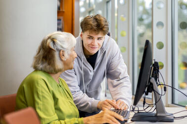 Kaksi henkilöä tietokoneen äärellä.