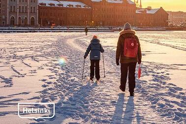 Ihmisiä kulkemassa jäällä kohti Katajanokkaa. Osa vuoden 2020 arviointikertomuksen kantta.