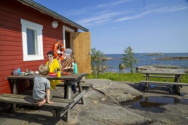 Punainen sauna Pihlajasaaressa meren rannalla.