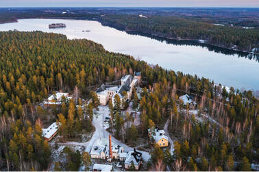 Sairaala-alue metsän keskellä järven rannalla.