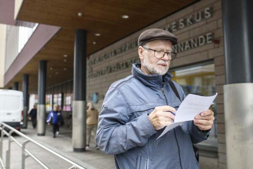 Mies lukee kädessään olevaa paperia. Mies lukee kädessään olevaa paperia.