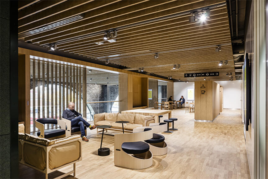 Henkilö istuu aulassa ja selailee puhelinta. Henkilö istuu aulassa ja selailee puhelinta.