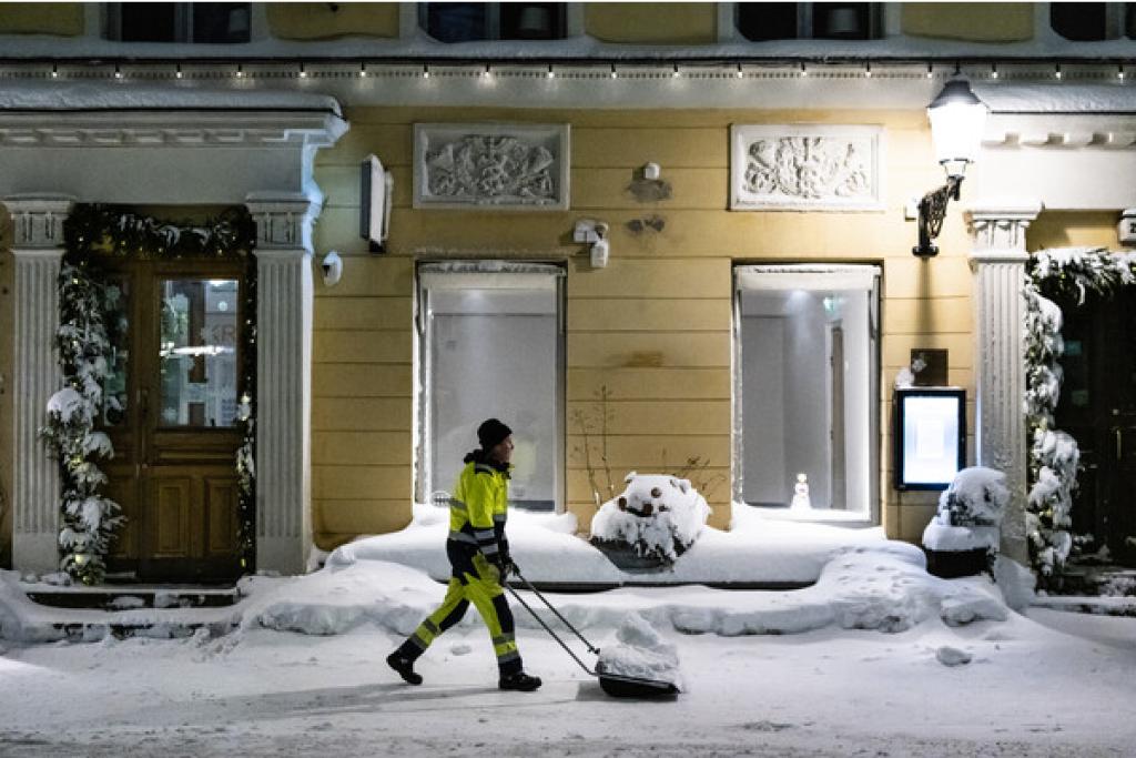 Lumitöitä tehdään myös yöllä. Kuvassa lumitöitä tekevä työmies Helsingin keskustassa.