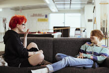 Kaksi nuorta istuu sohvalla nuorisotilassa