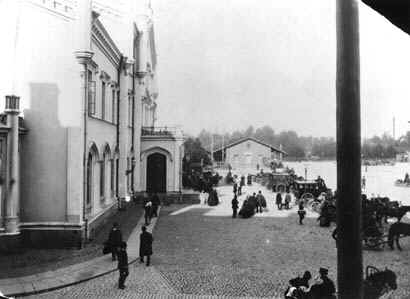 Vuokra-ajureita ja diligenssej odottamassa matkustajia Helsingin rautatieasemalla. Kuva 1892. HKM